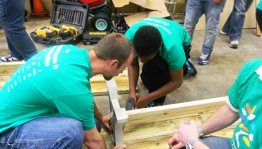Big Brother Cory builds a bench to beautify a local school as part of Comcast Cares Day